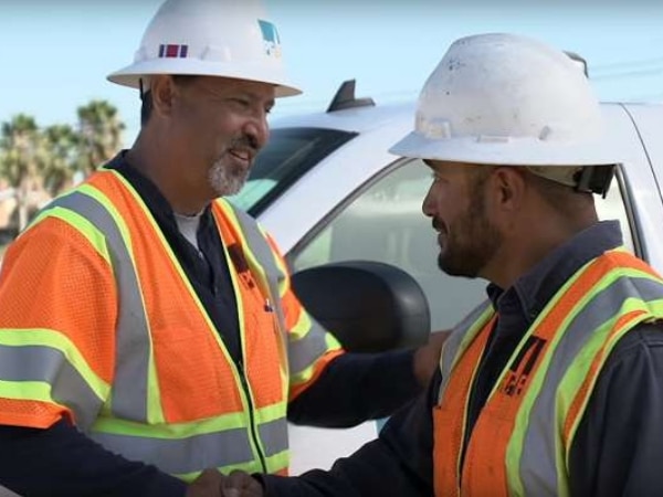 Field workers smile and shake hands
