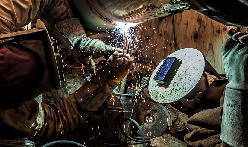 Two welders working on a pipeline weld