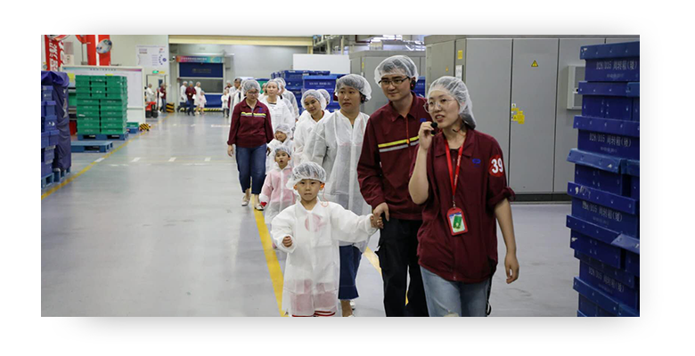 员工带着孩子参观中国高露洁棕榄厂