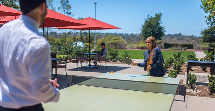 two associates playing ping pong 