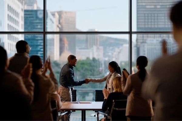 Colleagues Shaking Hands by a Window