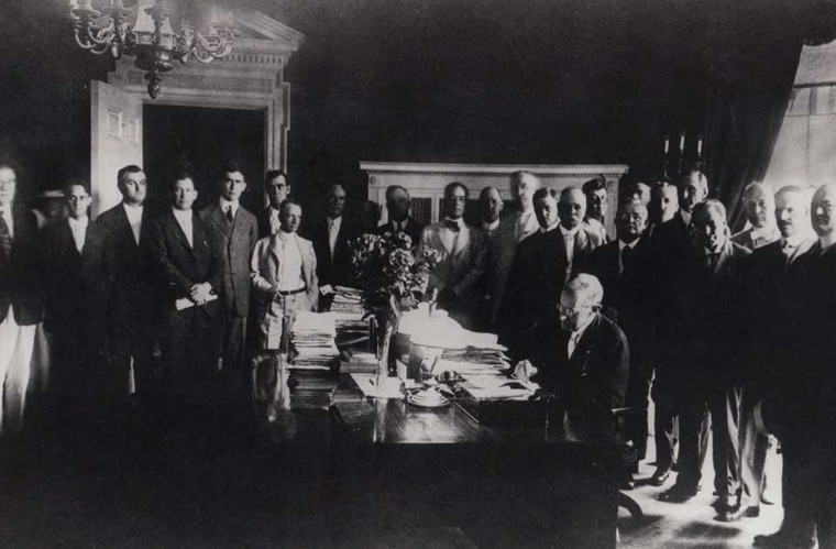 Black and white image of President Wilson signing Farm Credit Act. 