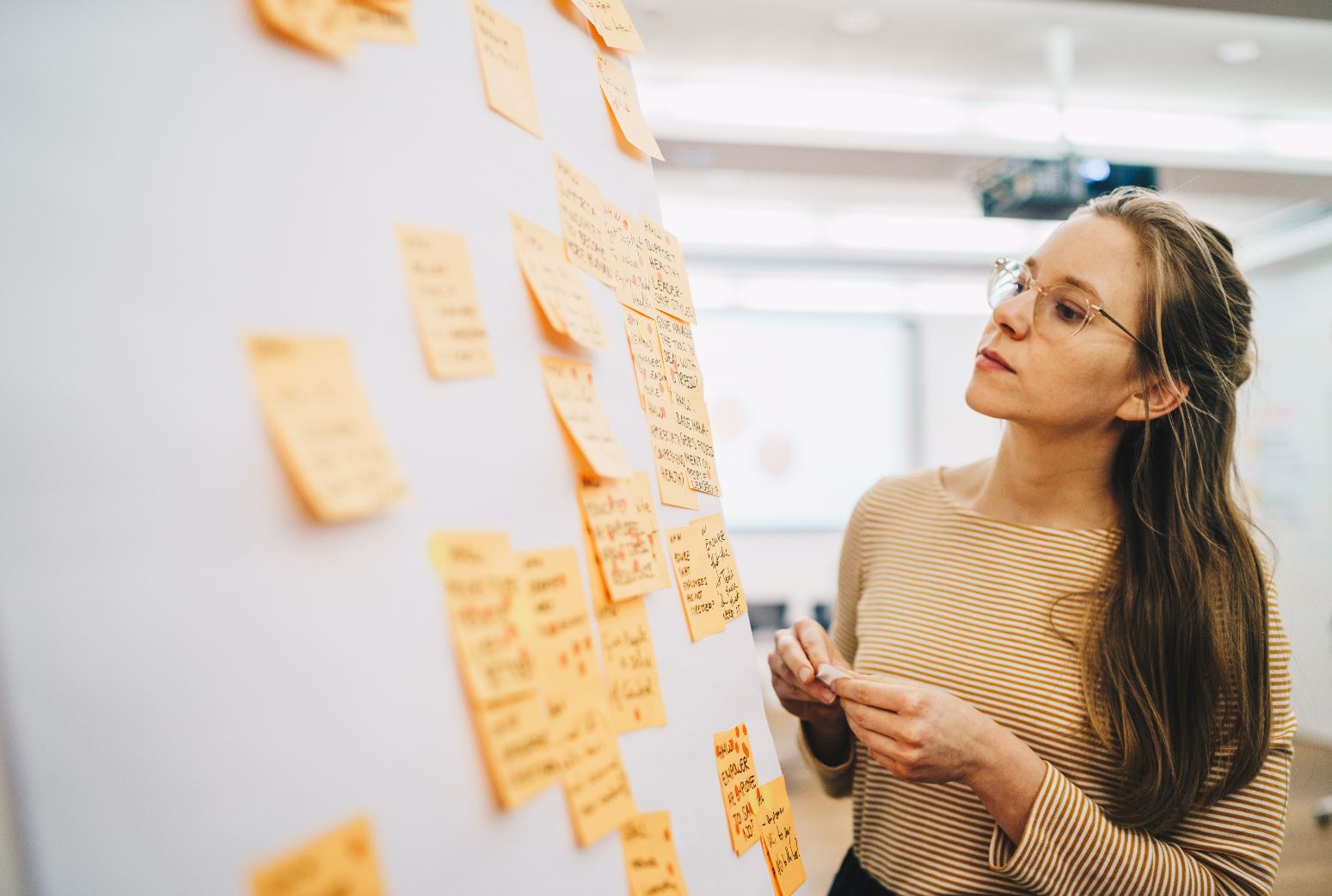 An image showing a woman working on whiteboard 