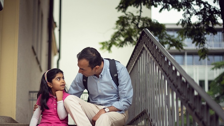 A person sitting with a girl child 