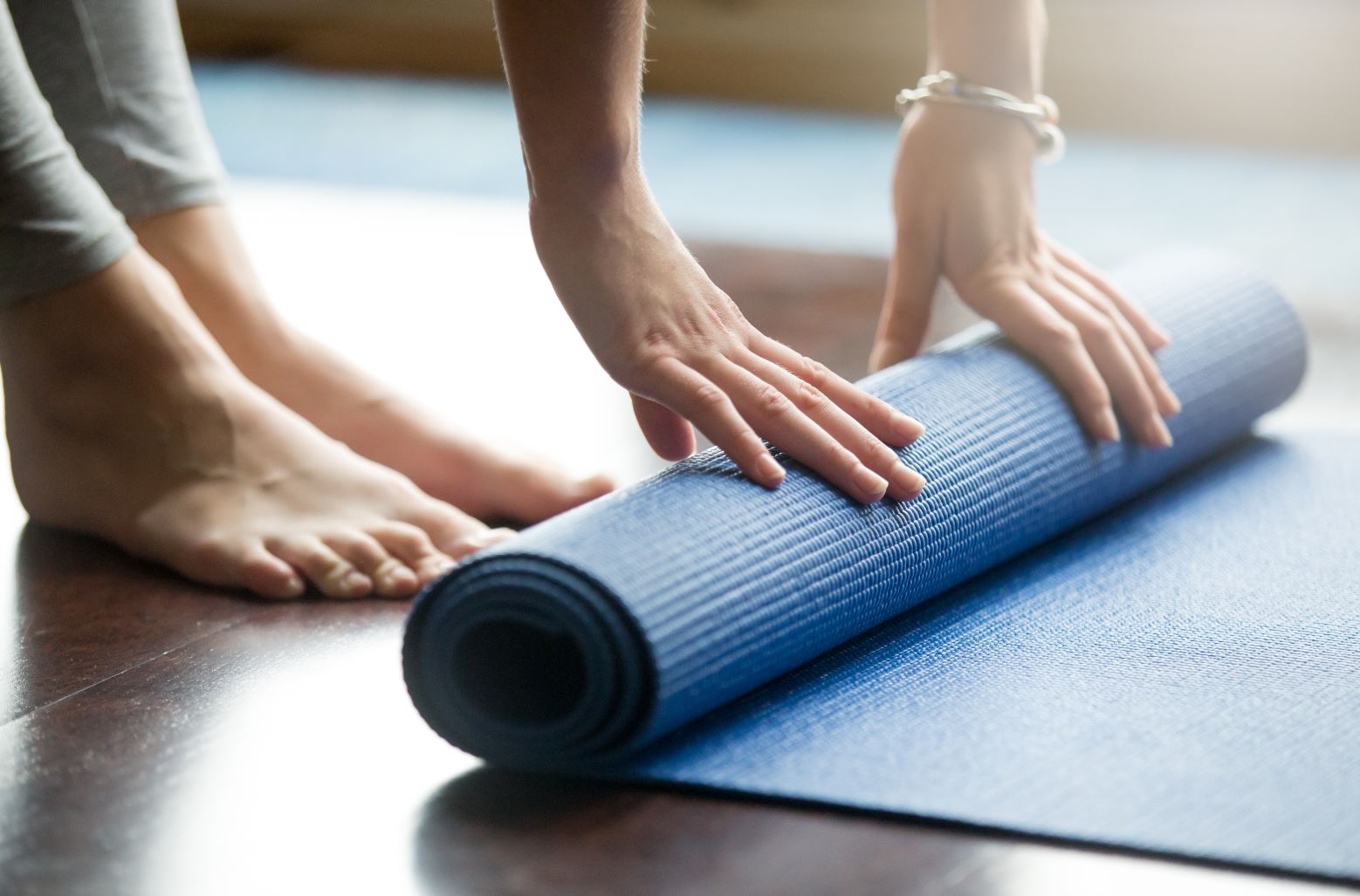 An image showing a person folding yoga mat