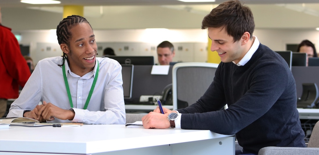 Two young male workers at a desk