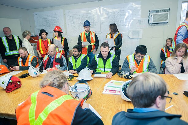 Employees in a team meeting on a Graham project site.