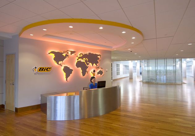 Shelton's front desk sits in front of the BIC logo and world map.
