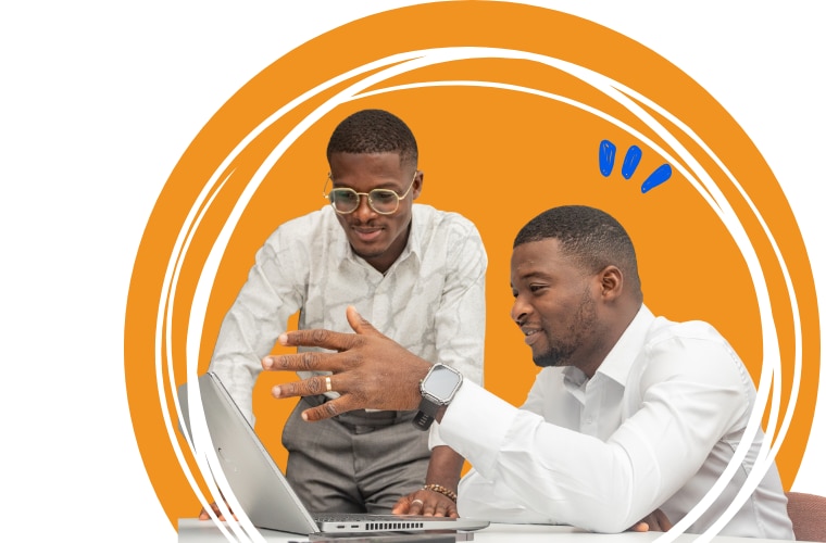 Two men at a table, working together on a laptop, sharing ideas and insights.