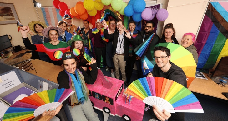 A group of staff members celebrating LGBTQIA+ diversity.